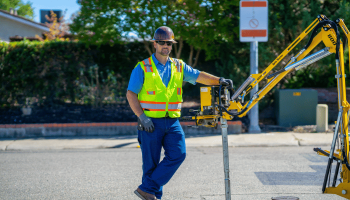 A water professional stands beside equipment during field work.